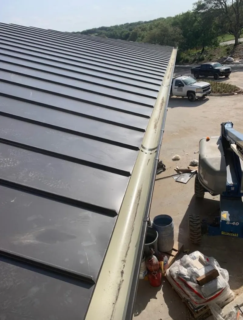 Standing seam panel and gutter detail on a metal roofing jobsite in Doolittle